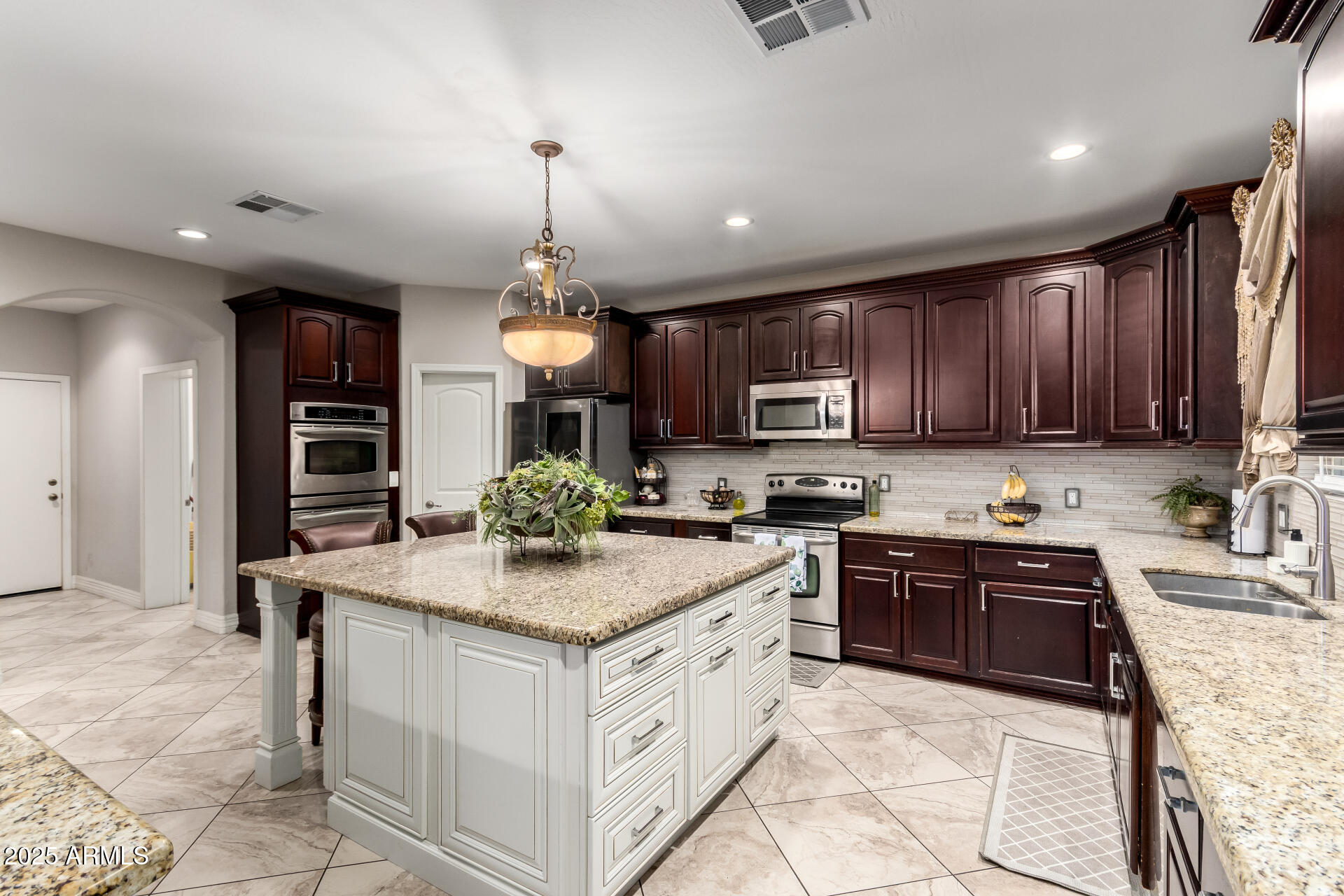 6344 West Lamar Road Glendale, AZ 85301 - Photo 19 of 37 a kitchen with kitchen island granite countertop stainless steel appliances a stove sink microwave and cabinets