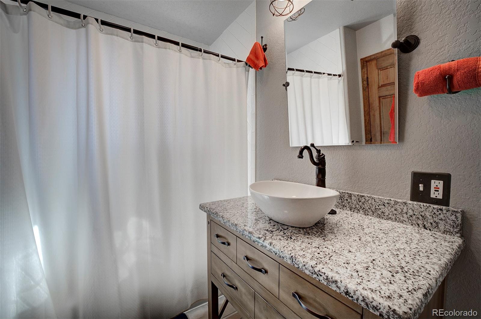 371 Hall Road Bailey, CO 80421 - Photo 23 of 40 a bathroom with a granite countertop sink and a mirror