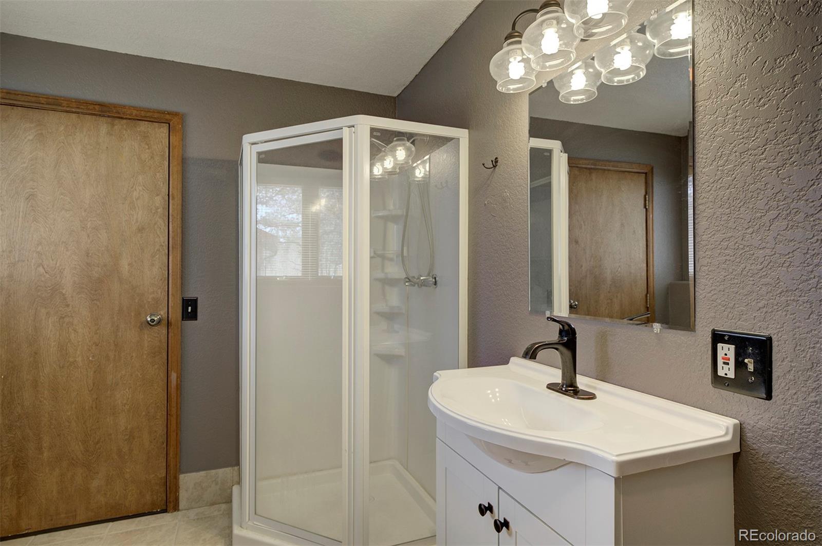 371 Hall Road Bailey, CO 80421 - Photo 33 of 40 a bathroom with a sink a mirror and a shower