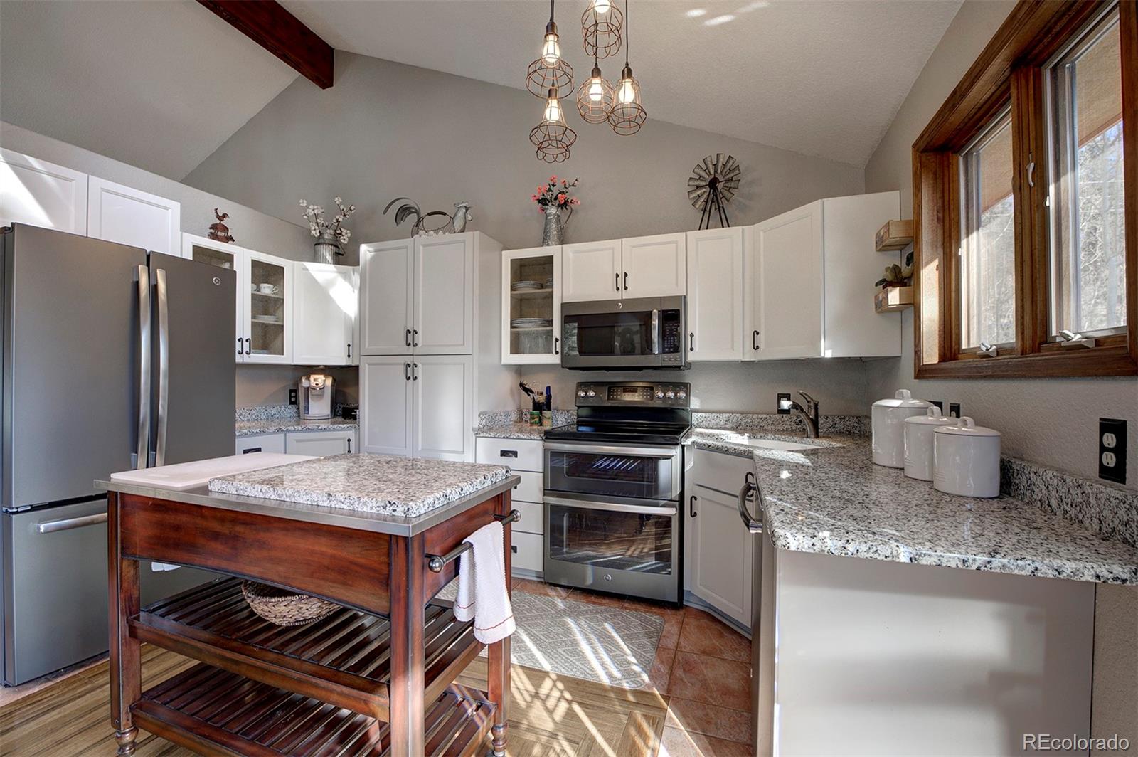 371 Hall Road Bailey, CO 80421 - Photo 5 of 40 a kitchen with stainless steel appliances granite countertop a stove refrigerator sink and microwave