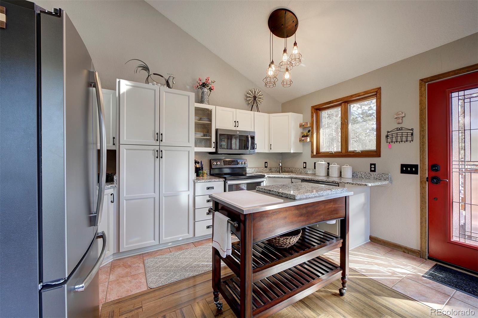 371 Hall Road Bailey, CO 80421 - Photo 6 of 40 a kitchen with stainless steel appliances a stove a refrigerator and cabinets