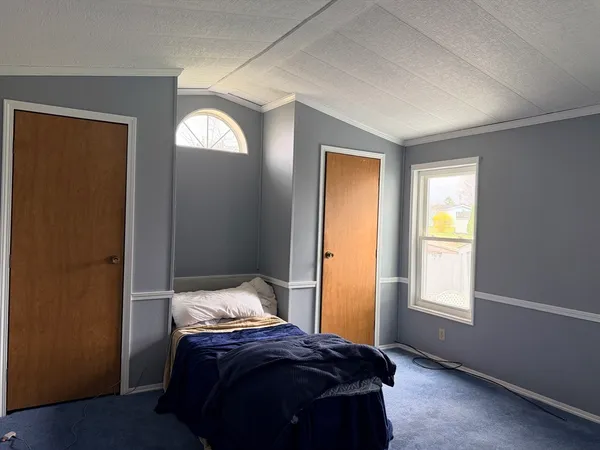 a bedroom with a bed and a mirror