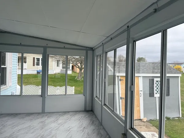 a view of an empty room with wooden floor and glass door