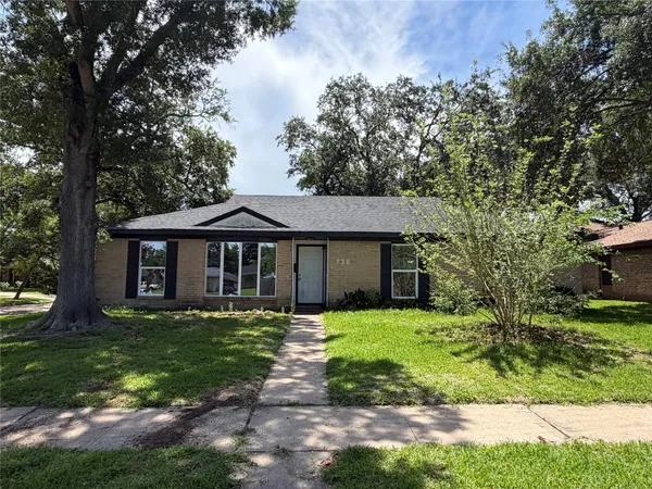 a front view of a house with yard and green space