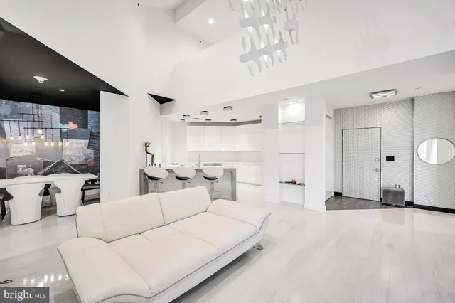 a living room with furniture a large window and white doors