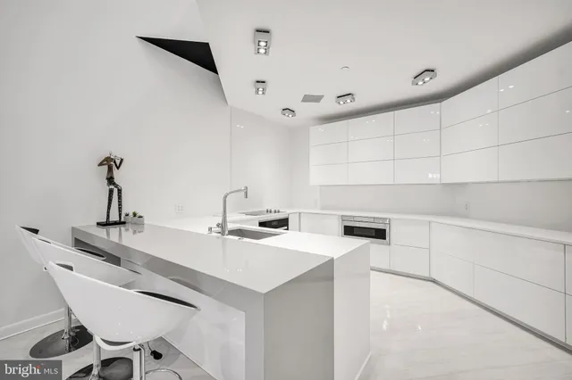 a kitchen with a sink a stove a refrigerator and white cabinets