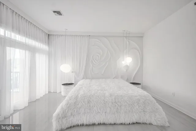 a large white bed in a white room