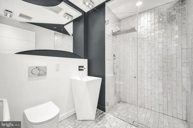 a white toilet sitting next to a bathroom sink