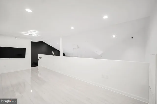 a view of an empty room with wooden floor