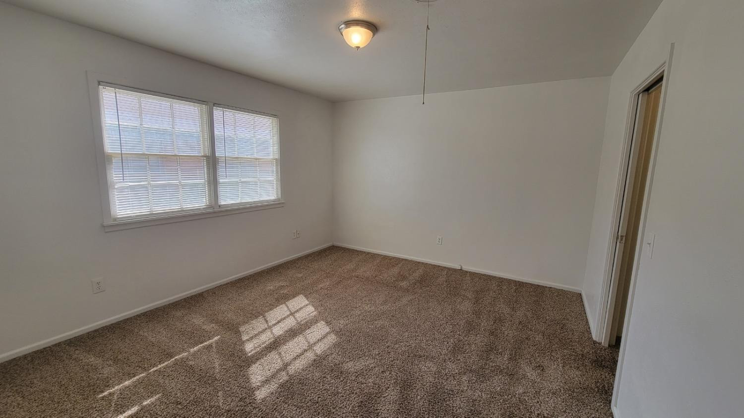 4205 50th Street, Unit A Lubbock, TX 79413 - Photo 4 of 10 an empty room with a window