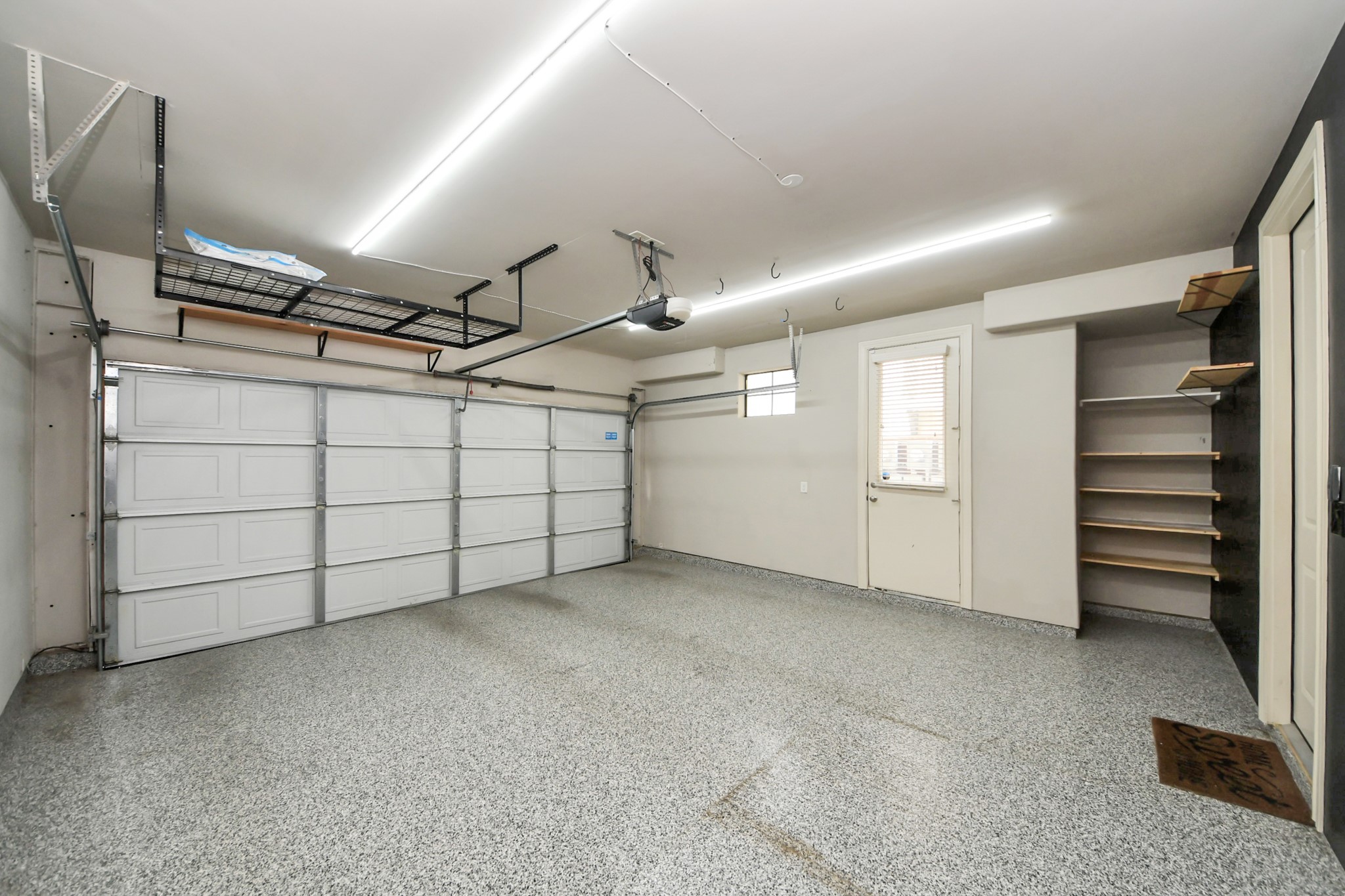 3229 Maxroy Street Houston, TX 77008 - Photo 40 of 43 2 car garage featuring epoxy flooring, overhead storage.