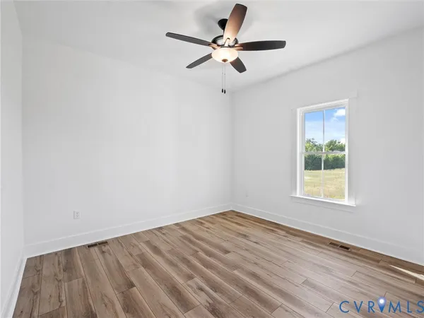 an empty room with a window and a fan