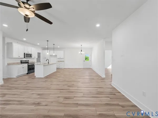 a view of kitchen with kitchen island white cabinets and stainless steel appliances