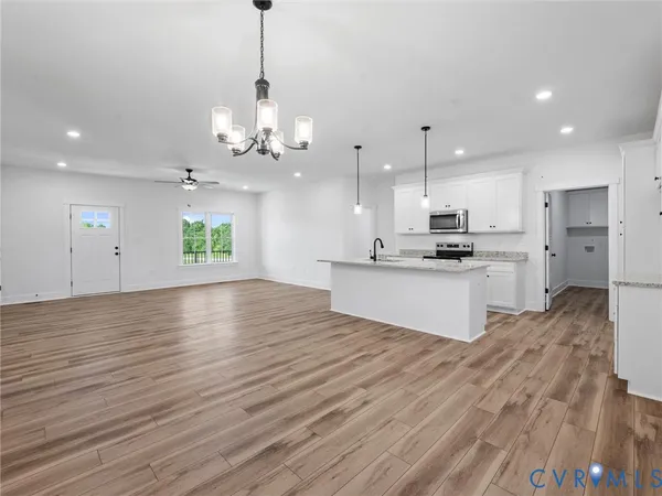 a view of a kitchen with kitchen island a sink stainless steel appliances and cabinets