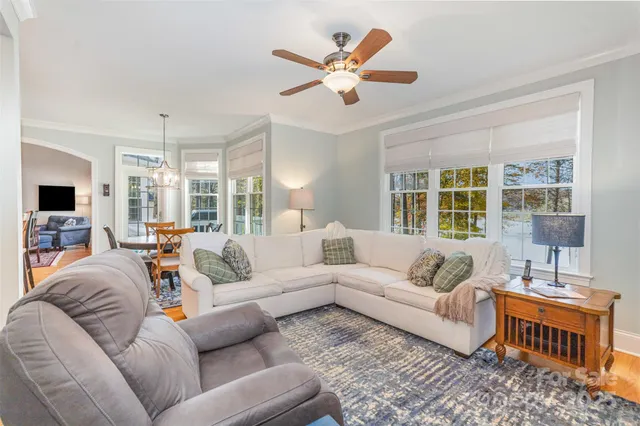 a living room with furniture ceiling fan and a window