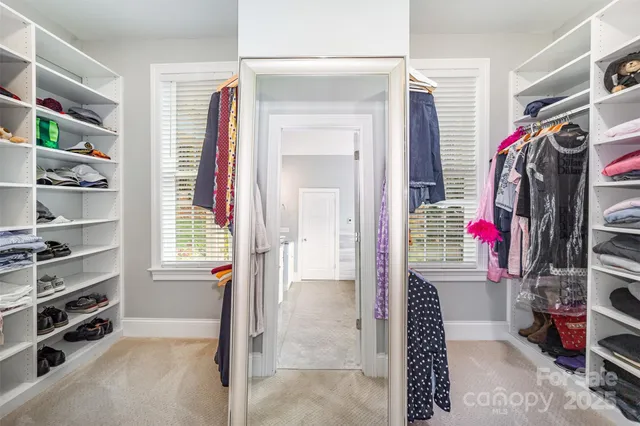 a view of walk in closet with clothes and shoes