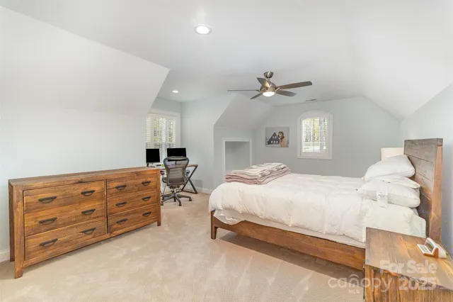 a bedroom with a large bed and a ceiling fan