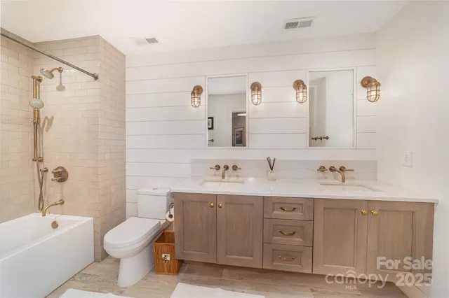 a bathroom with a granite countertop sink a toilet and a bathtub