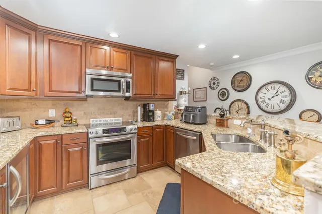 a kitchen with stainless steel appliances granite countertop a stove top oven a sink and dishwasher