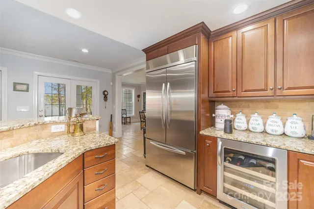 a kitchen with granite countertop a refrigerator and cabinets