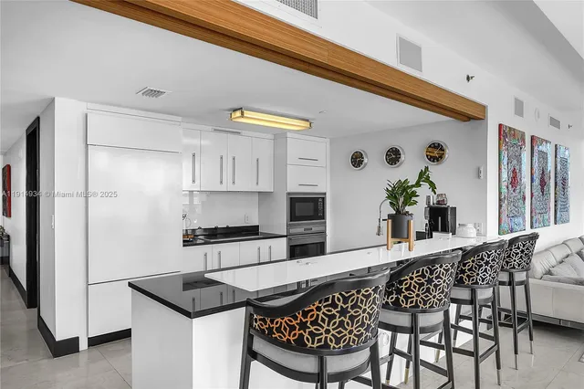 a kitchen with stainless steel appliances kitchen island granite countertop a refrigerator and a stove