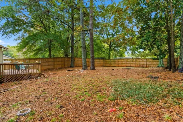 a backyard of a house with large trees and covered with tall trees