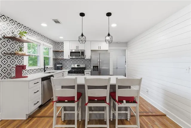 a kitchen with stainless steel appliances kitchen island granite countertop a sink and cabinets