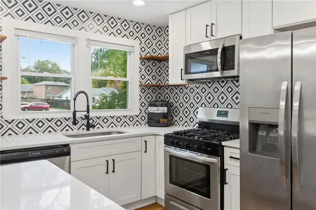 a kitchen with stainless steel appliances a sink stove and refrigerator