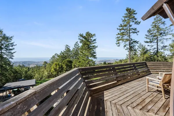 a view of balcony with wooden floor and trees