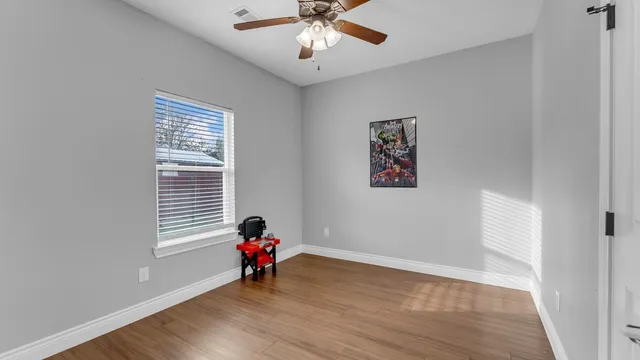 a view of room with hardwood floor and a ceiling fan