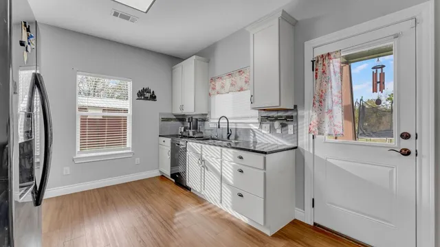 a kitchen with granite countertop a sink stove and cabinets