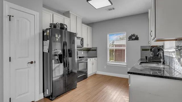 a kitchen with granite countertop a refrigerator and a sink
