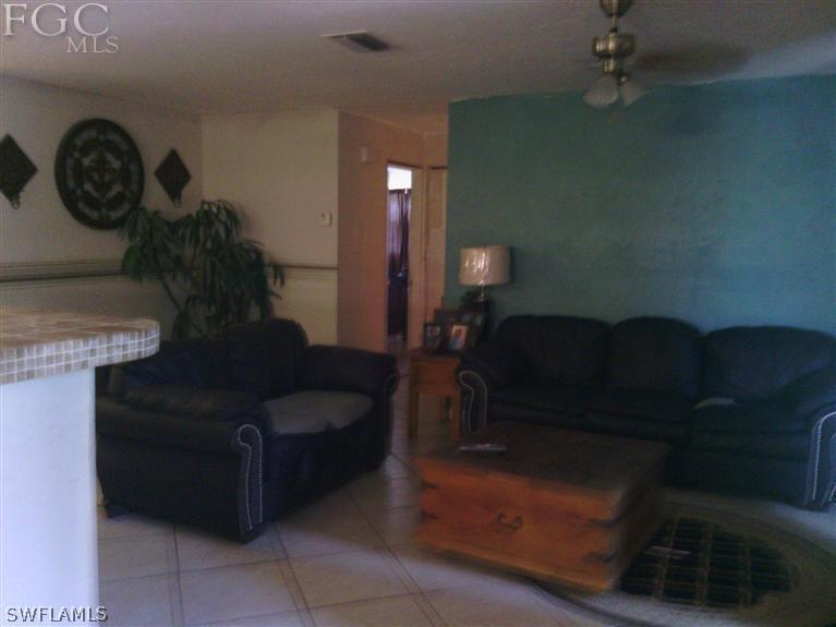 504 Penn Road West Lehigh Acres, FL 33936 - Photo 4 of 7 a living room with furniture and a mirror