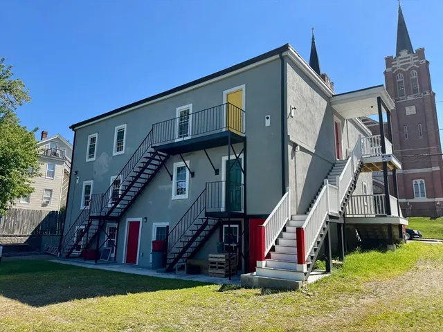 a view of small house with yard and green space