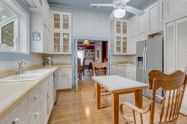 a kitchen with stainless steel appliances granite countertop a kitchen island a stove a table and chairs in it