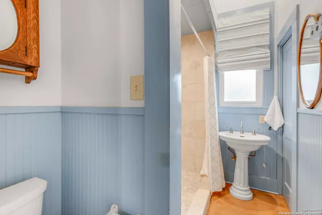 a bathroom with a sink a toilet and a mirror