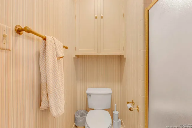 a bathroom with a toilet and a shower curtain