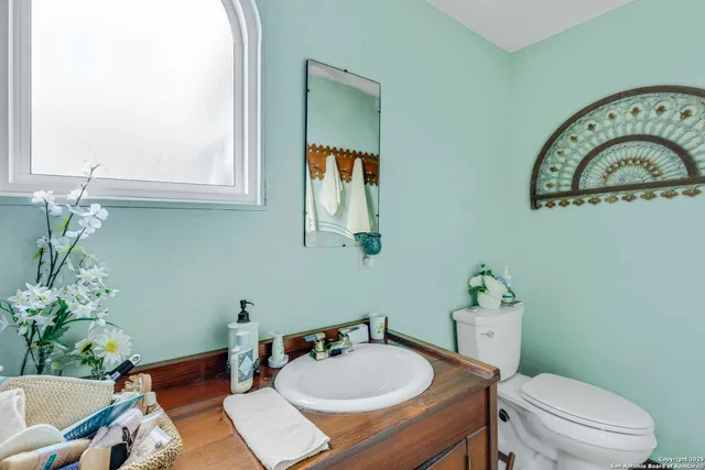 a bathroom with a sink mirror vanity and toilet