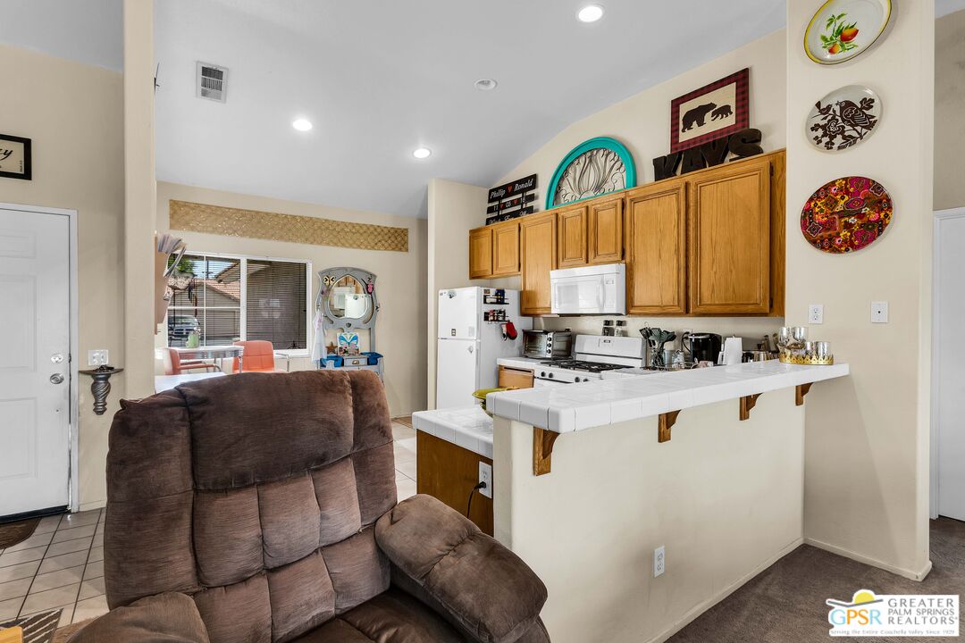 13753 Inaja Street Desert Hot Springs, CA 92240 - Photo 12 of 24 a view of kitchen island with stainless steel appliances granite countertop a stove a sink and a refrigerator
