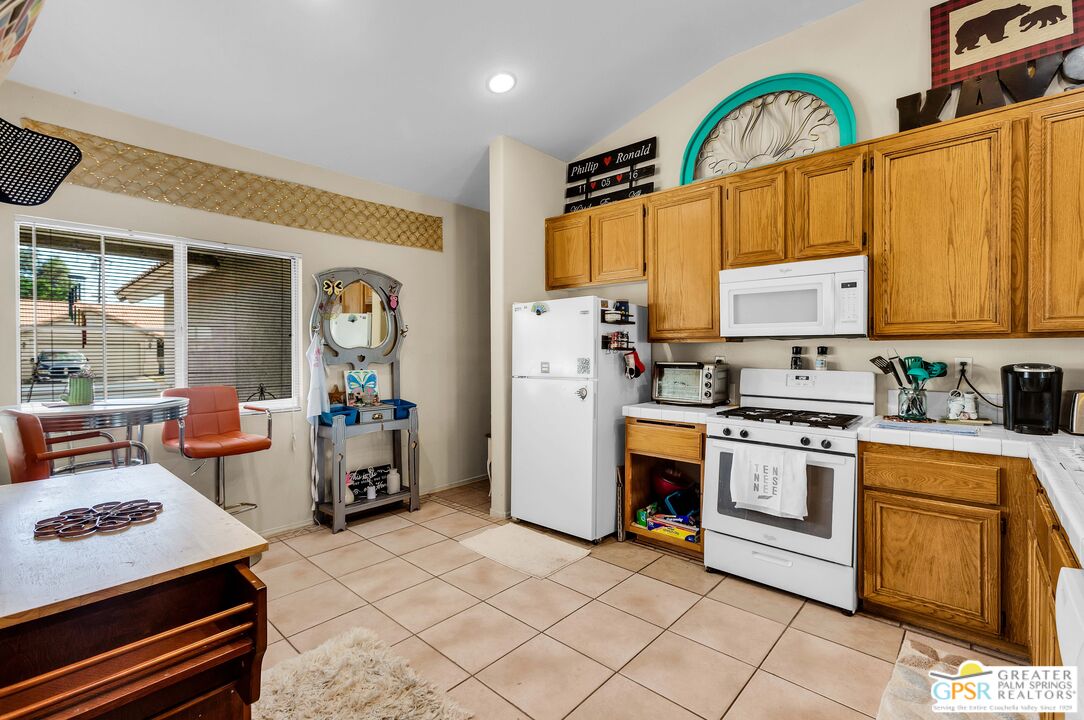 13753 Inaja Street Desert Hot Springs, CA 92240 - Photo 4 of 24 a kitchen with stainless steel appliances a stove a sink dishwasher and cabinets