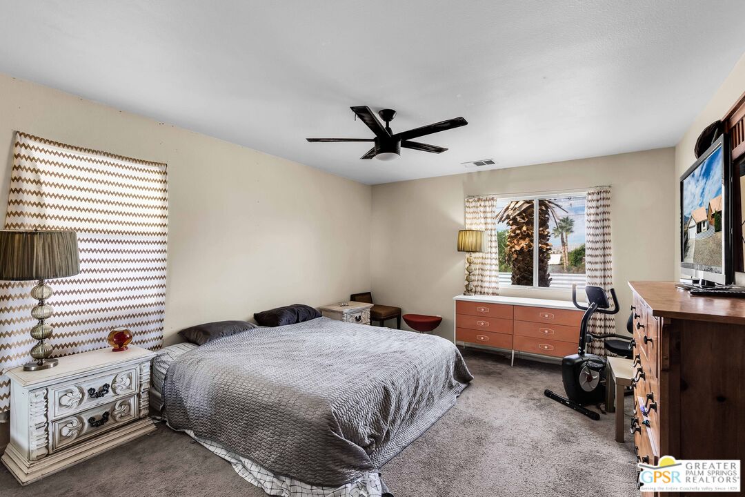 13753 Inaja Street Desert Hot Springs, CA 92240 - Photo 5 of 24 a bedroom with a bed and a chandelier