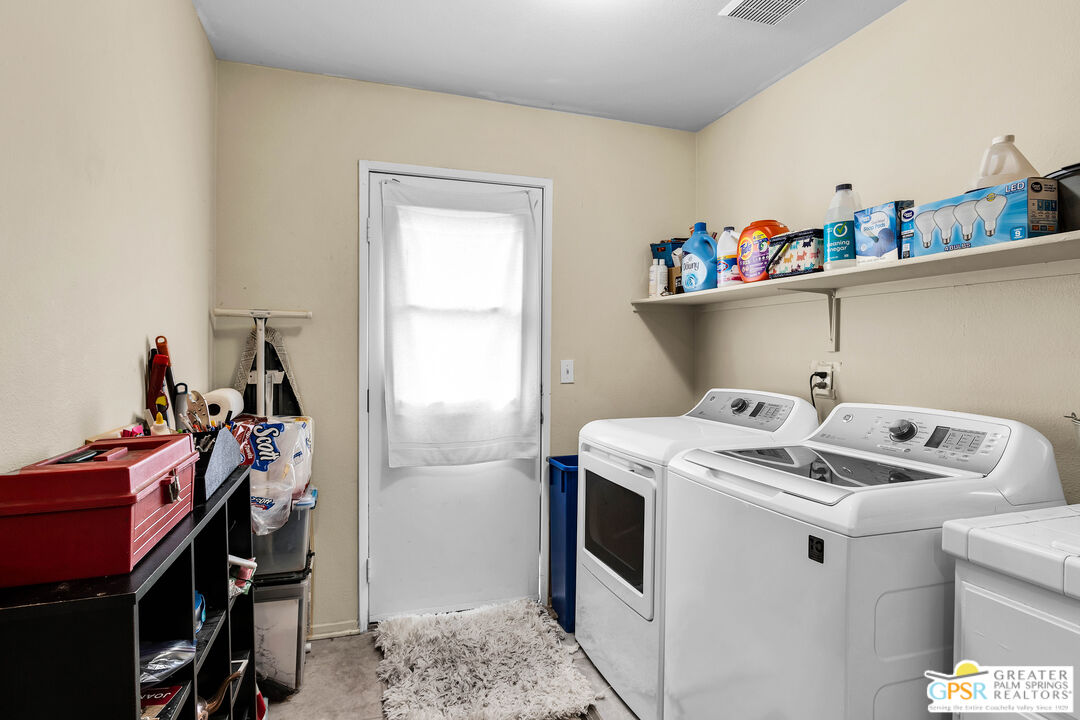 13753 Inaja Street Desert Hot Springs, CA 92240 - Photo 8 of 24 a utility room with dryer washer and a fridge
