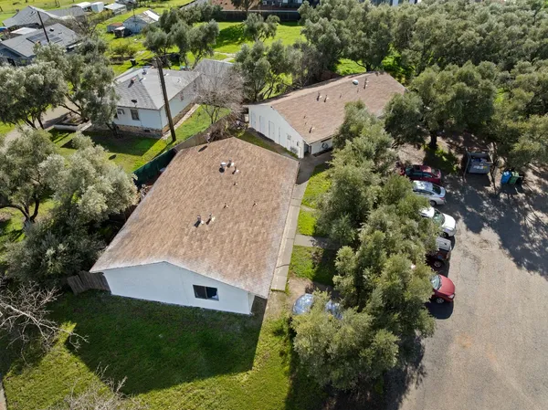 a view of a house with a big yard and large trees