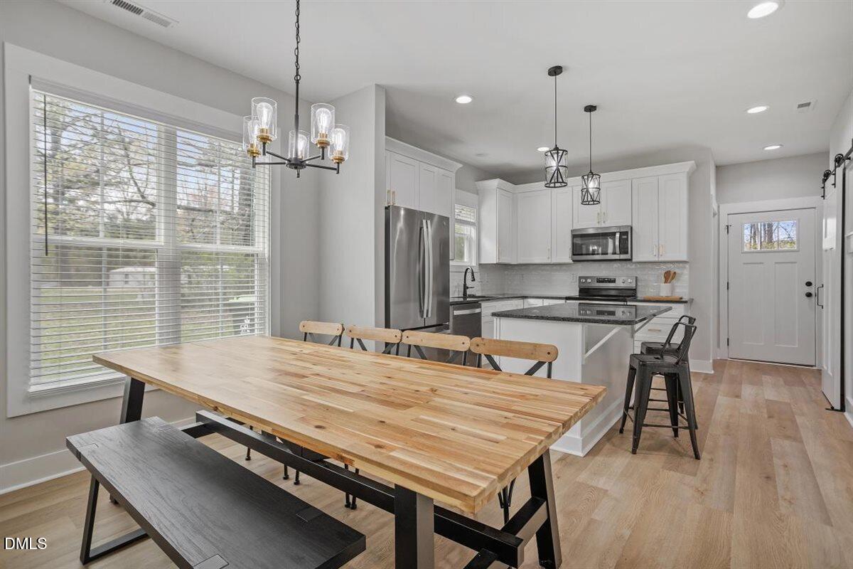 506 Dogwood Road Holly Springs, NC 27540 - Photo 11 of 42 a room with kitchen island a wooden floor and a view of dining room