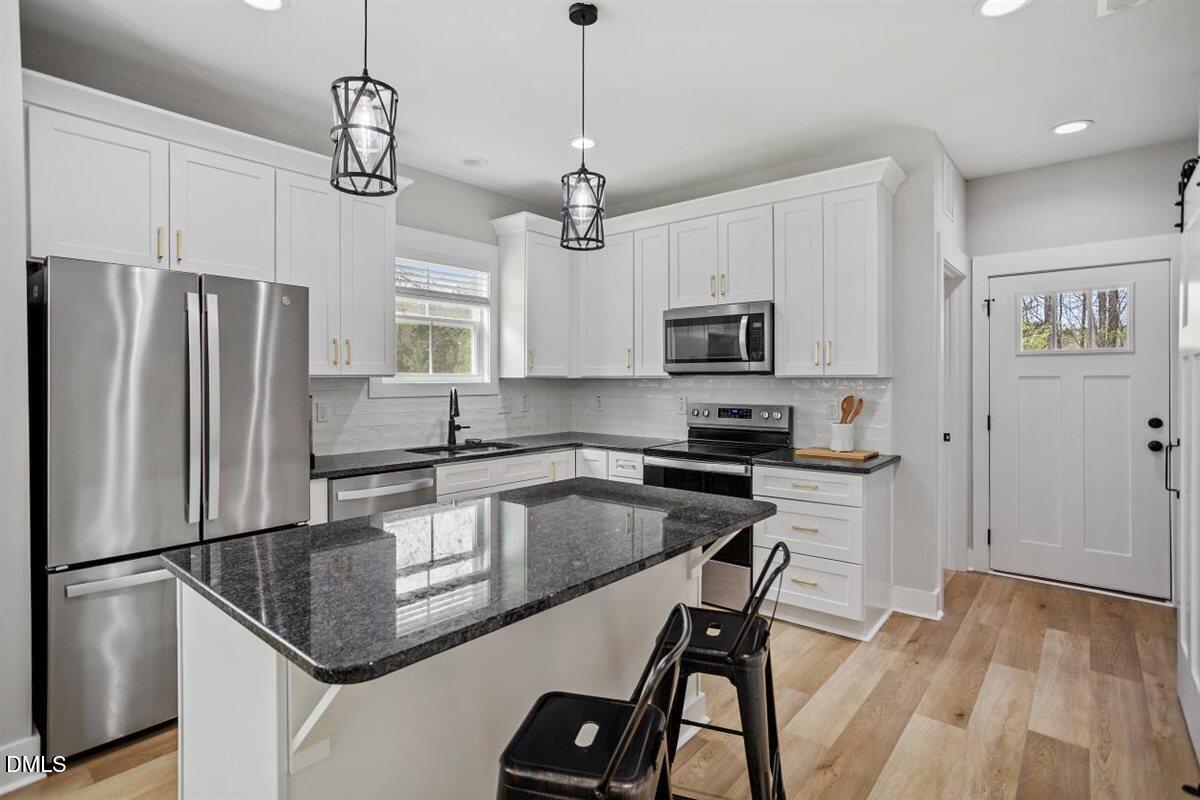 506 Dogwood Road Holly Springs, NC 27540 - Photo 13 of 42 a kitchen with kitchen island a counter space a sink appliances and cabinets