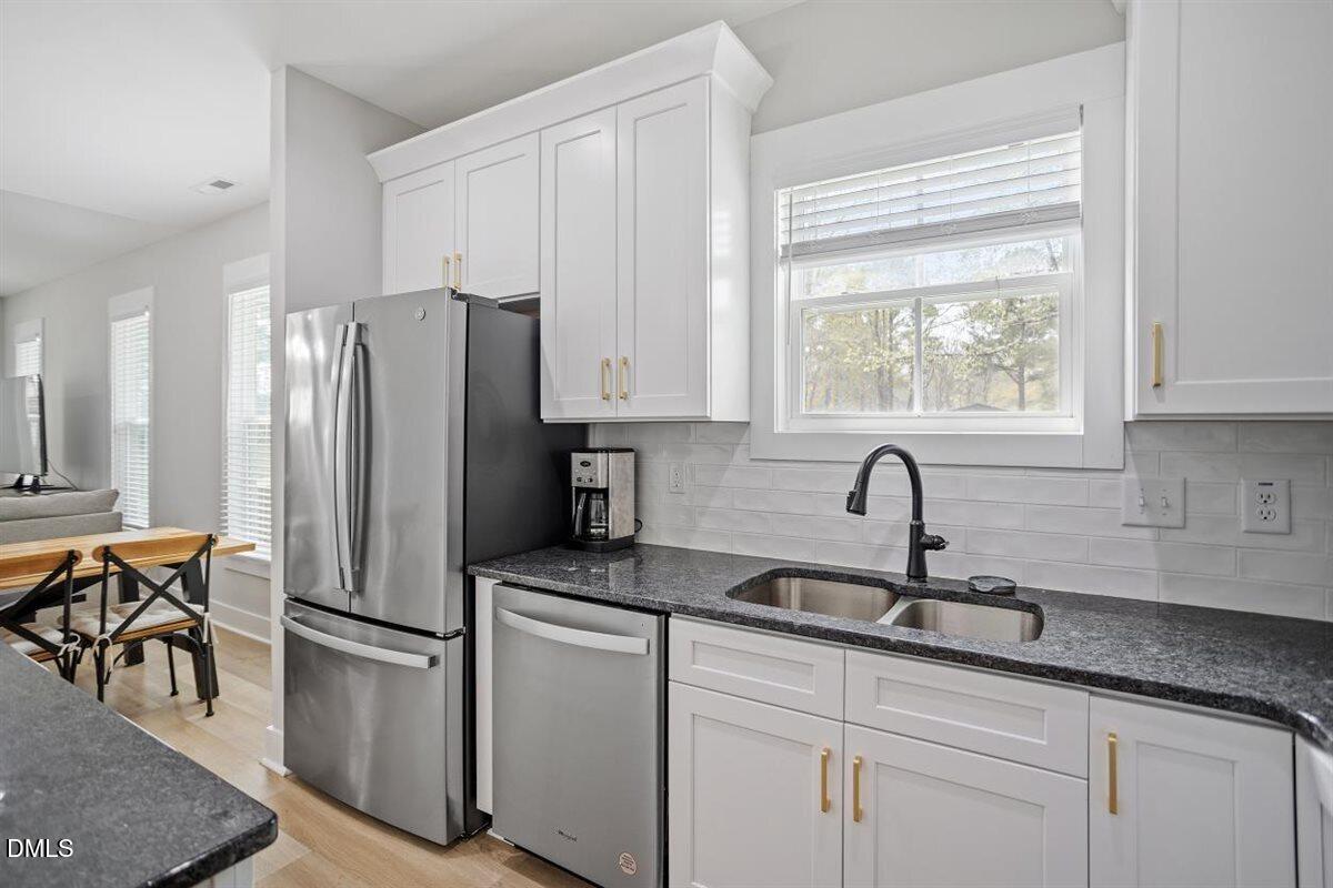 506 Dogwood Road Holly Springs, NC 27540 - Photo 15 of 42 a kitchen with stainless steel appliances granite countertop a refrigerator sink and cabinets