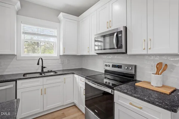a kitchen with appliances a sink and cabinets