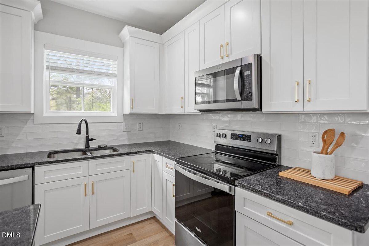 506 Dogwood Road Holly Springs, NC 27540 - Photo 17 of 42 a kitchen with appliances a sink and cabinets