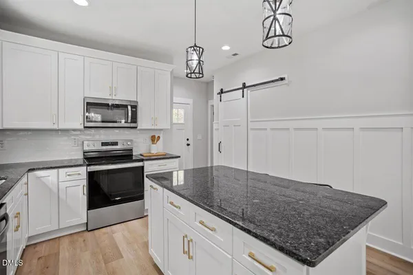 a kitchen with stainless steel appliances granite countertop a sink a stove top oven a counter space and cabinets