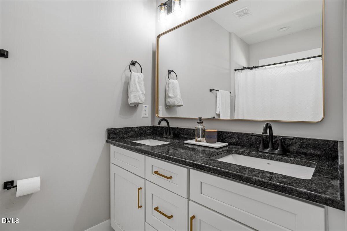 506 Dogwood Road Holly Springs, NC 27540 - Photo 25 of 42 a bathroom with a granite countertop sink and a mirror